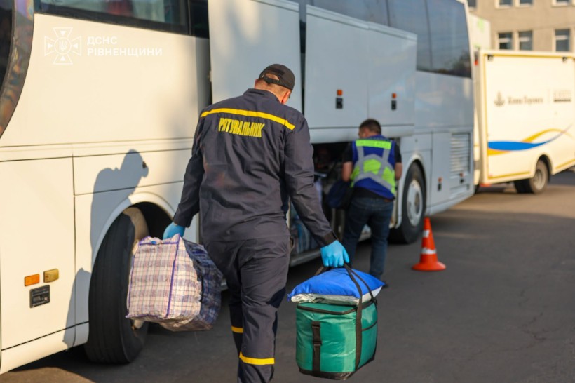 Рятувалньик вантажить речі до автобусу