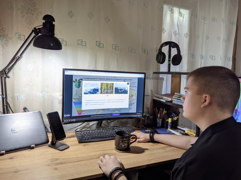 Підліток сидить перед ноутбуком на спільному онлайновому заході