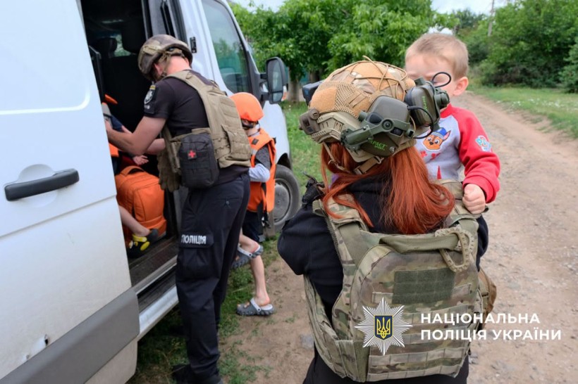 Поліцейські допомагають дітям сісти в евакомобіль
