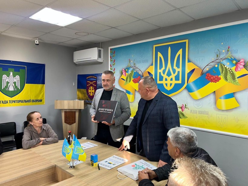 Начальник Сіверської міської військової адміністрації Олексій Воробйов дарує книгу про Донеччину новим партнерам