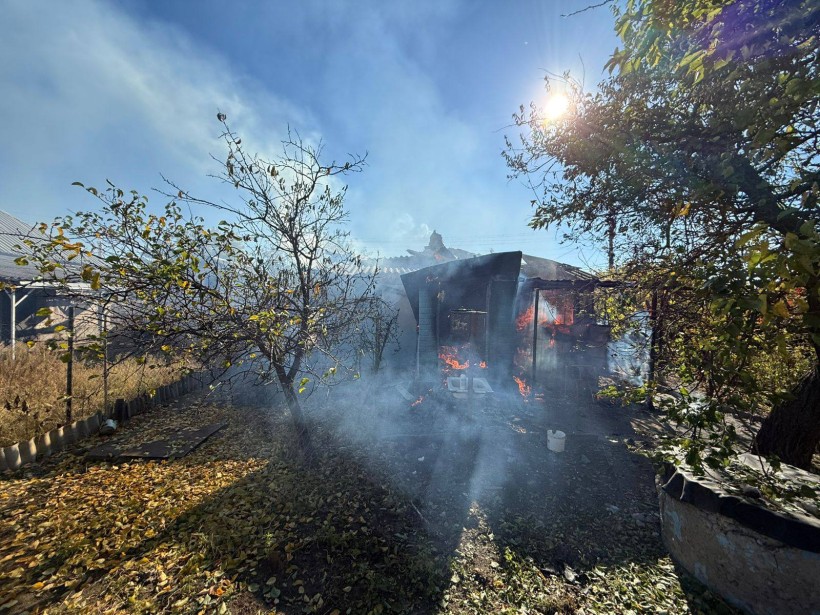 Палаюча будівля після ворожого обстрілу