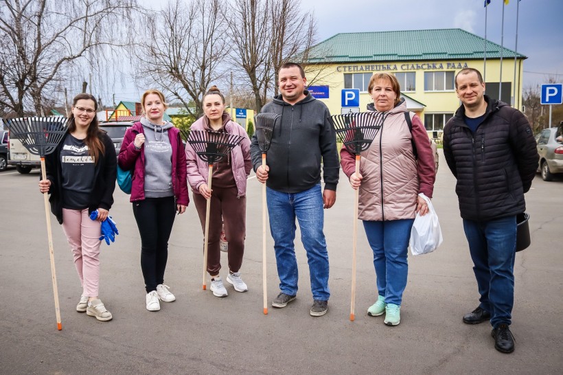 Учасники акції, тримають у руках садовий інвентар, спільне фото