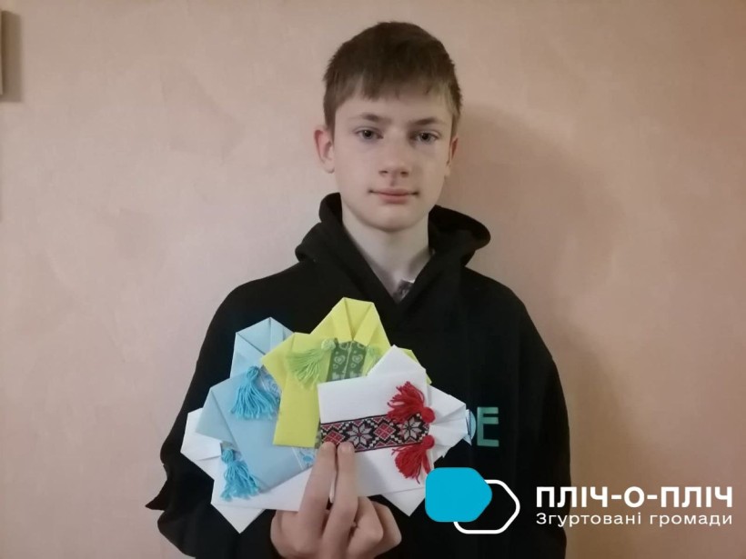 Хлопчик, учасник онлайн-майстерні з оригамі зі своїми поробками