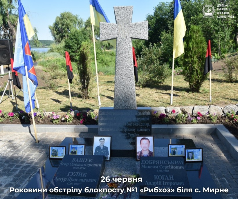 Урочисте меморіальне місце прикрашає високий червоно-коричневий обеліск, оточений зеленню. Біля його підніжжя покладені квіти.