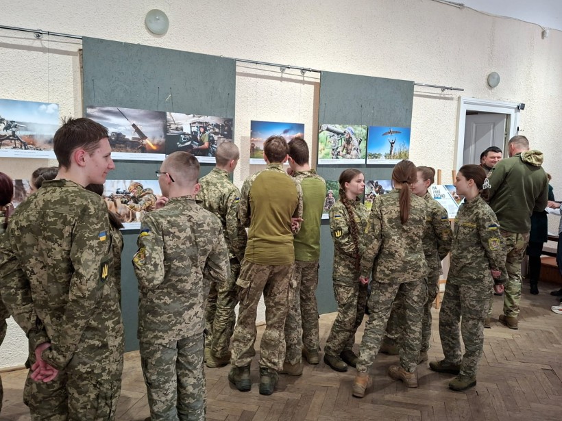 Військовослужбовці переглядають представлені на виставці картини