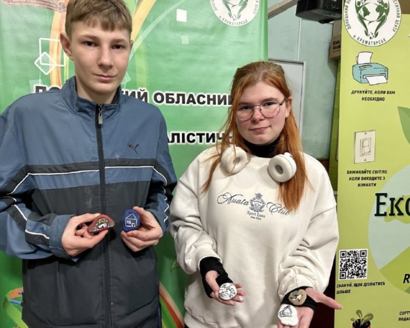 Художній розпис на камені «Екохатинка». Учасники тримають у руках виконані роботи
