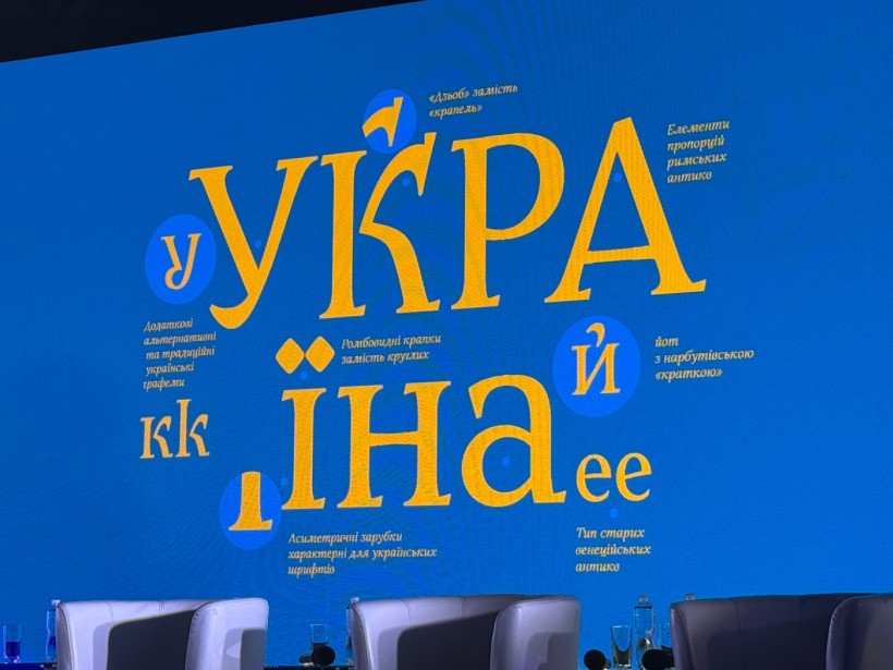 Слайд презентації на синьому фоні з великим жовтим написом «Україна» та текстовими поясненнями щодо особливостей шрифту.