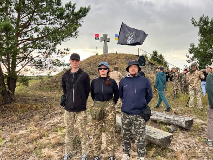 Молодь Донеччини на меморіальному місці з прапорами та хрестом під час табору.