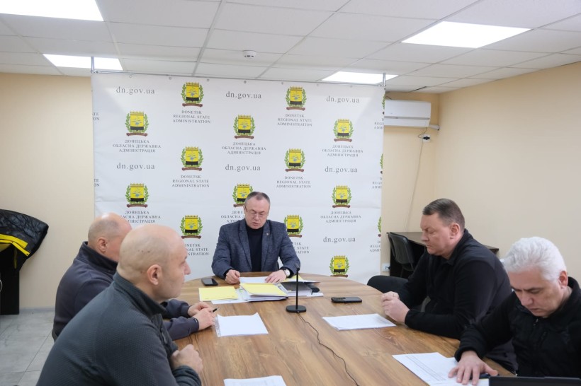 Члени наради сидять за столом.