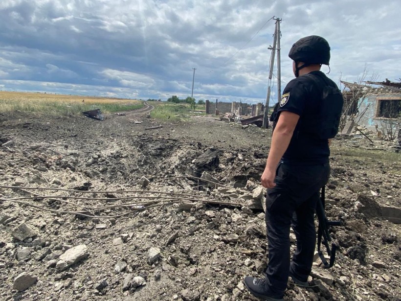 Рятувальник біля воронки від ворожого обстрілу.