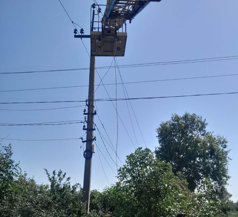 Електроопора, яку ремонтують енергетики після ворожого обстрілу.