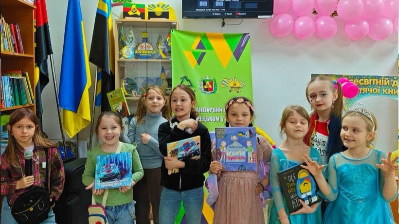 Діти з Торецької громади тримають книжки в руках та посміхаються