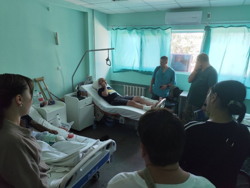 Лікарня. В палаті на ліжках лежать поранені захисники, поруч стоять лікарі та представники Гродівської громади.