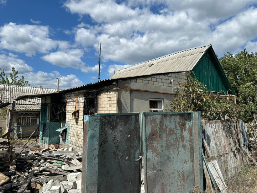 Пошкоджений одноповерховий будинок та двір