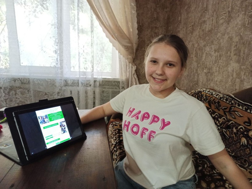 Учениця з Донеччини демонструє проєкт на планшеті під час участі у всеукраїнському конкурсі «Зелена естафета».