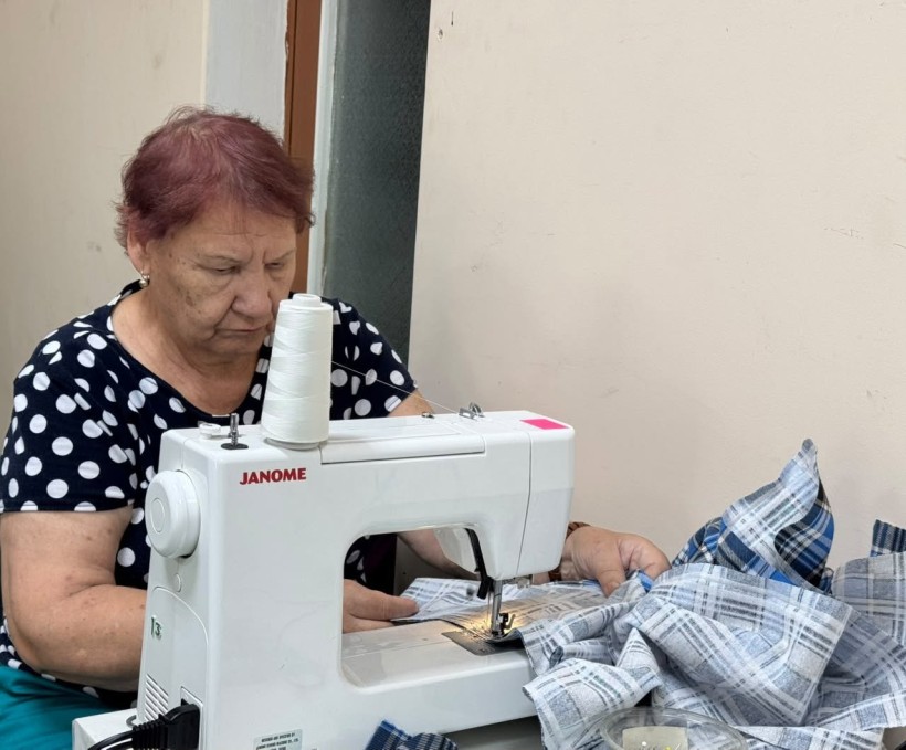 Жінка на машинці шиє одяг для захисників