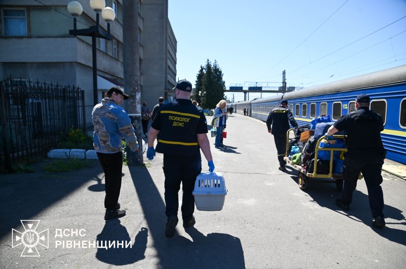 Рятувальники зустрічають людей з евакуаційного потяга, який придув до Рівненської області