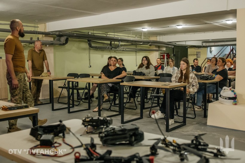 Молодь Донеччини слухає військових під час зустрічі в межах проєкту «Наша Донеччина. Наш дім. Наша фортеця». На передньому плані — елементи дронів.