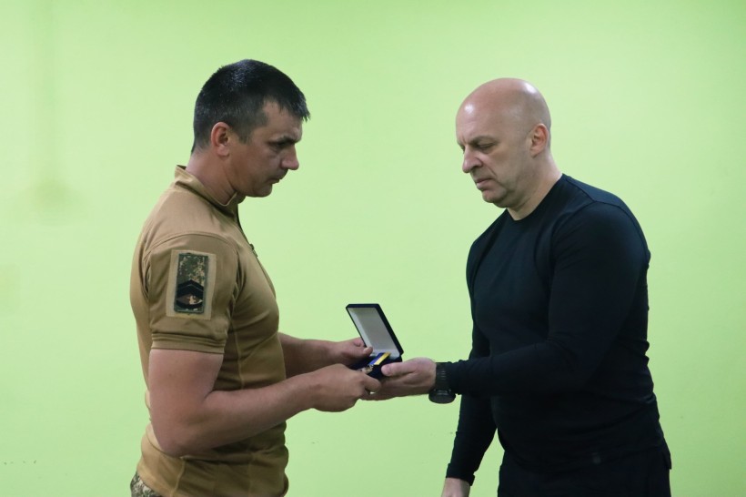 Боєць Національної гвардії отримує нагороду від Вадима Філашкіна.