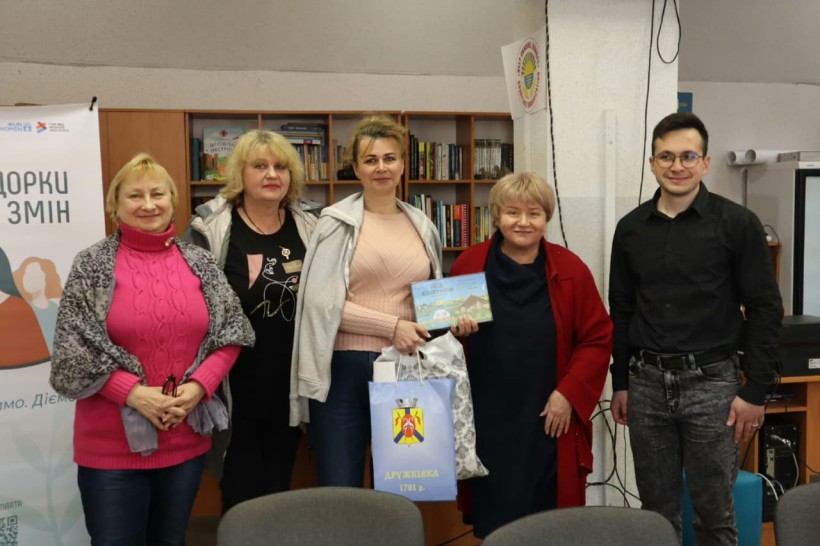 Спільне фото учасників зустрічі, одна з учасниць тримає у руках настільну гру "Код Донеччини".