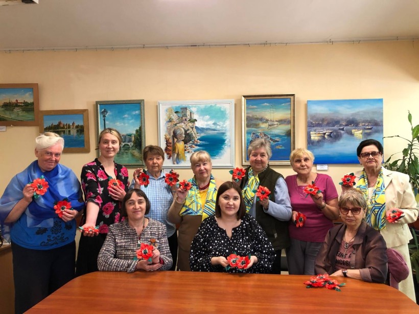 Спільне фото учасниць майстер-класу, які демонструють виготовлені власноруч червоні квіти маку