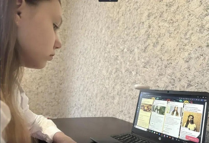 Дівчина сидить за ноутбуком та передивляється роботи учасників марафону на падлет-дошці