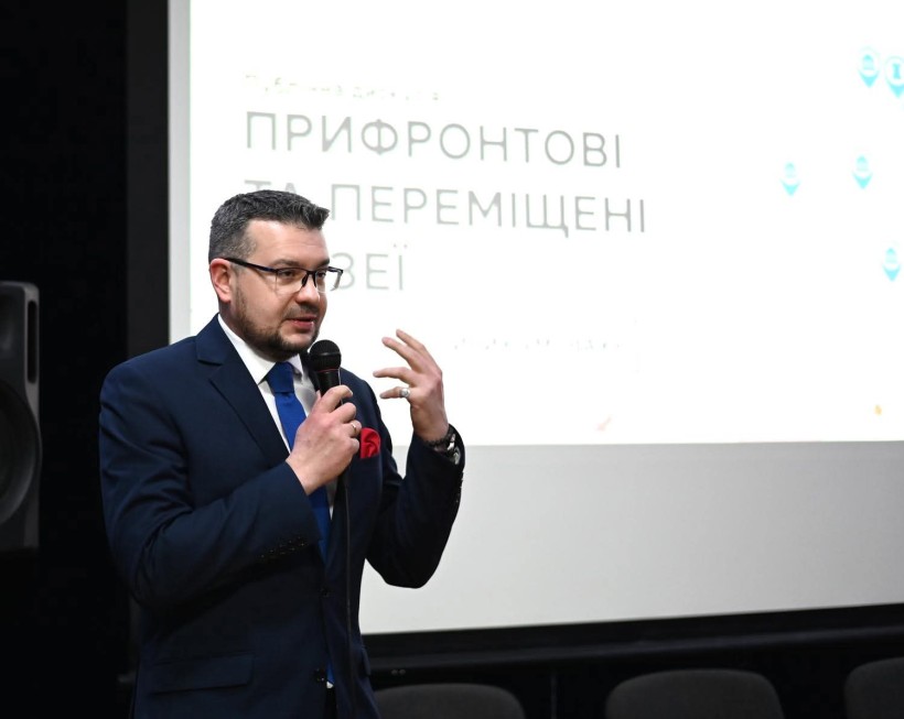 Спікер виступає на подіумі дискусії з мікрофоном