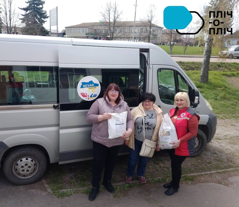 Представниці терцетру та Червоного Хреста біля автівки з гуманітарною допомогою