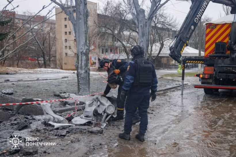 Працівники ДСНС обстежують місце потрапляння півторатонної авіабомби. На землі лежать залишки ворожої авіаційної бомби.