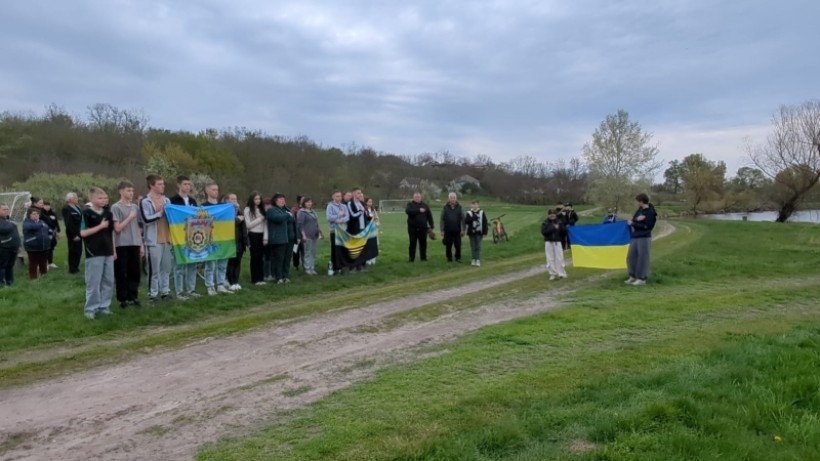 Учасники змагань співають гімн України та тримають прапори.