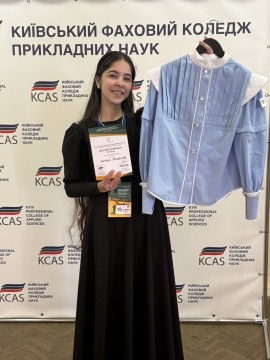 Студентка Варвара Коцубанова тримає адаптивну сорочку та диплом
