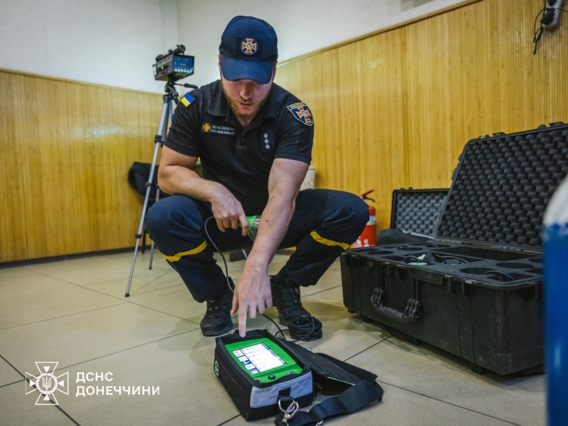 Рятувальник роздивляється нове обладнання, яке лежить на підлозі.