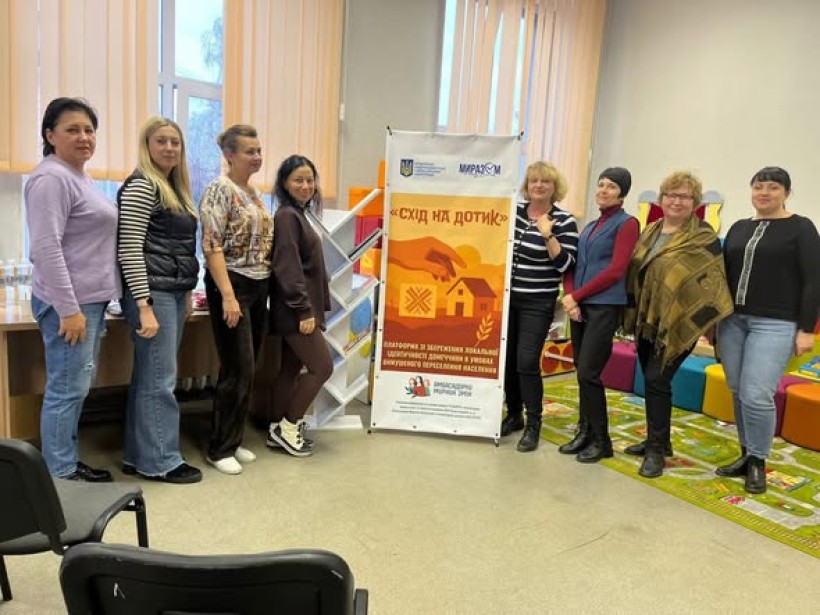 Презентація просторів, створених для переселенців Донеччини на базі Центрів підтримки ВПО Краматорського району МиРазом в м. Полтава та м. Дніпро. Жінки стоять біля банеру.