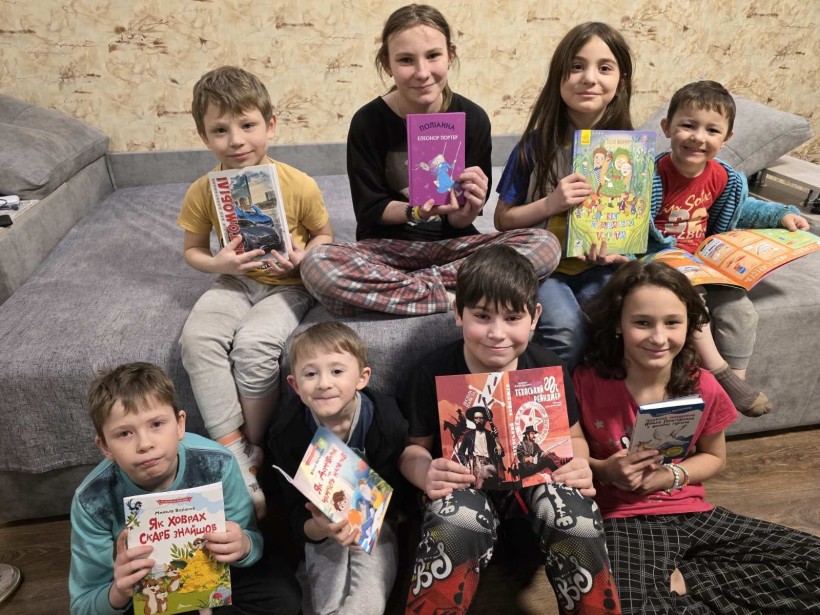 Діти посміхаються, тримаючи новенькі книжки