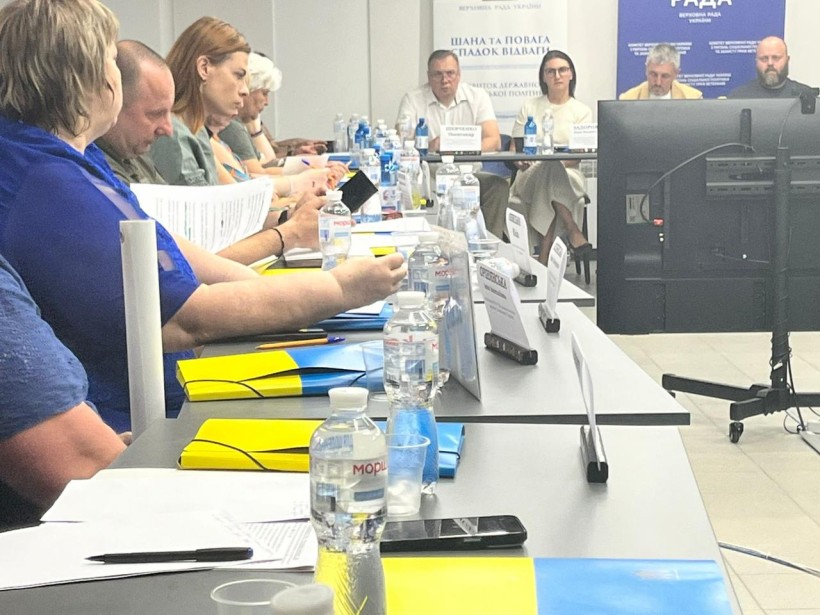 Учасники заходу слухають доповіді докладачів.