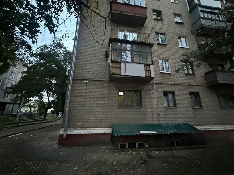 Багатоквартирний будинок з пошкодженими вікнами після ворожого обстрілу