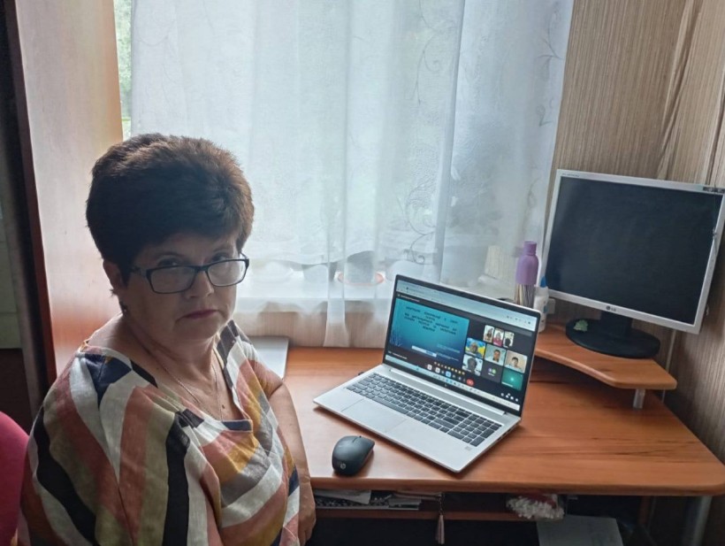 Представниця громади, яка приєдналась до онлайн вебінару. Поруч розташований відкритий ноутбук.
