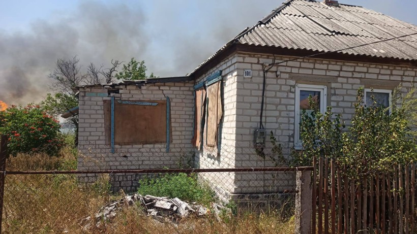 Одноповерховий будинок та пожежа на подвір'ї після обстрілу окупантів.
