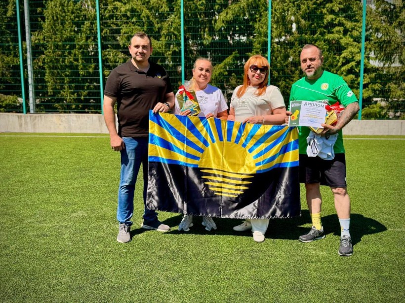 В.о. голови Краматорської райдержадміністрації, начальника районної військової адміністрації Вікторія Набокова та дружина загиблого захисника тримають прапор Донеччини, поруч стоять двоє чоловіків.