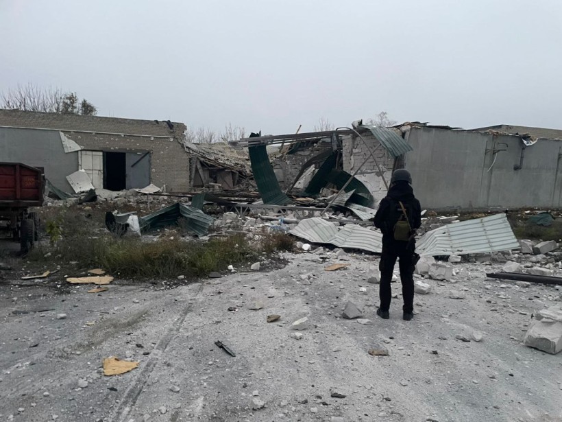 Правоохоронець стоїть біля зруйнованого промислового об'єкта