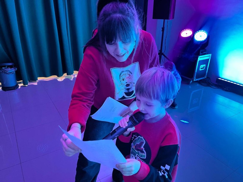 Хлопчик з мікрофоном співає