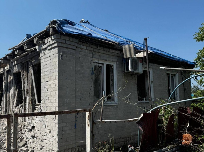 Пошкоджений одноповерховий будинок і зруйнована покрівля після ворожого обстрілу.