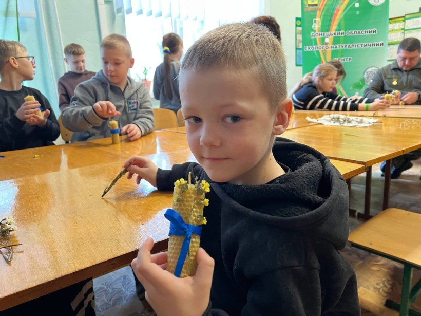 Хлопчик тримає готову аромасвічку, виготовлену власноруч