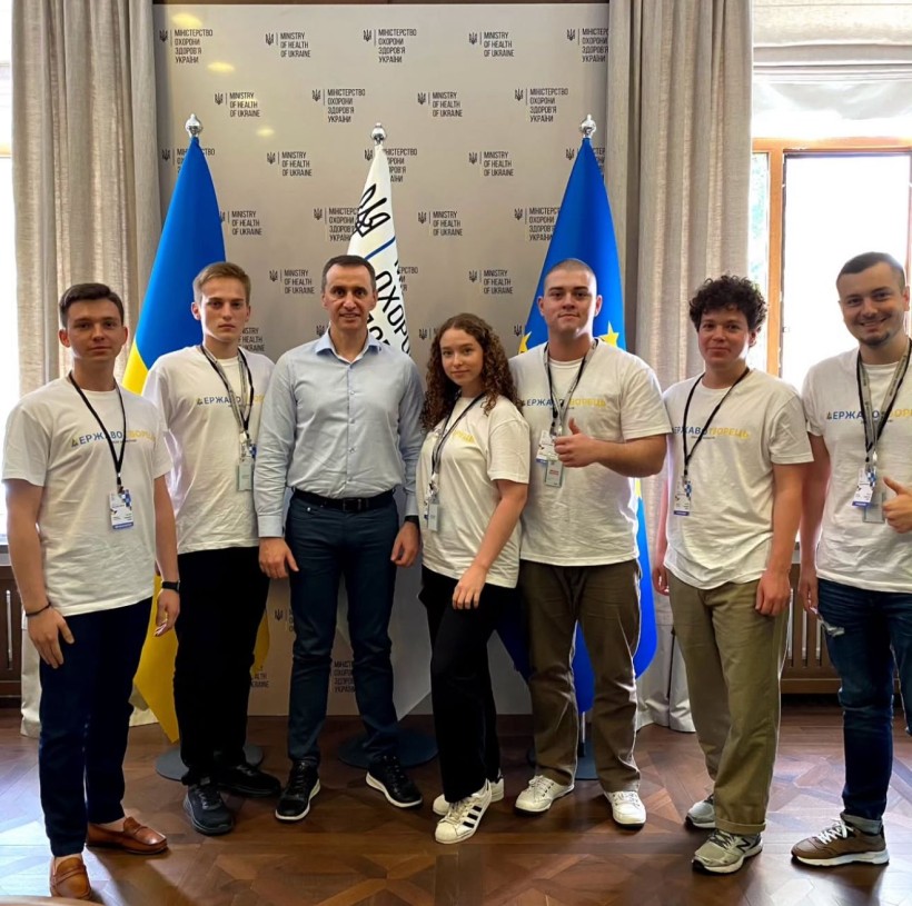 Віктор Ляшко, Міністр охорони здоровʼя, та студенти стоять біля прапорів: України, Міністерства охорони здоров'я та Євросоюзу.