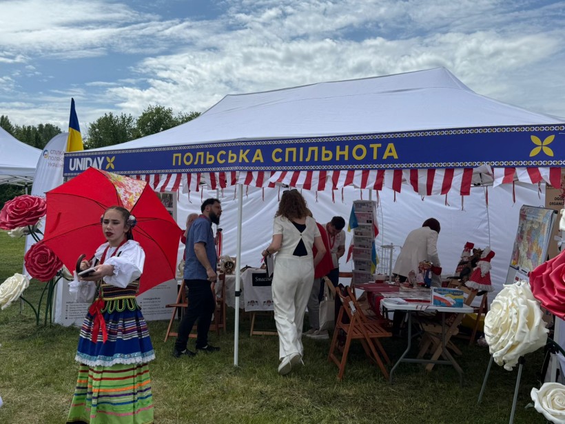 Люди в наметі з написом "Польська спільнота"