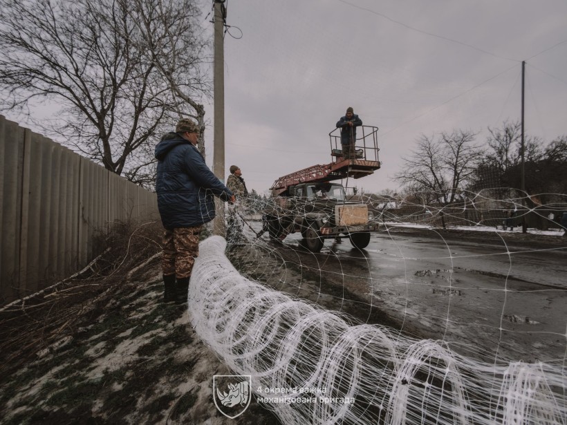 Бійці 4-ї механізованої бригади зводять антидронові сітки над населеним пунктом Донеччини