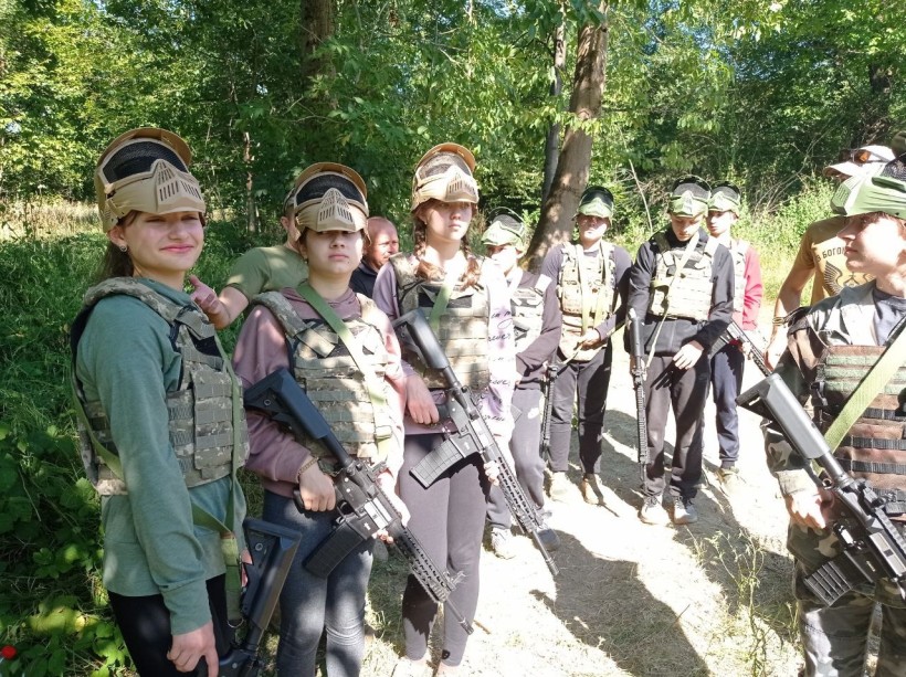 Юнаки та дівчата у спеціальній формі готуються до змагань зі стрільби
