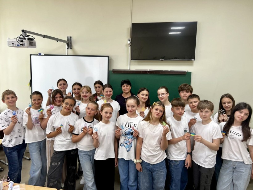 Спільне фото дітей, які тримають у руках патріотичні сувеніри (тризуби, прапори)