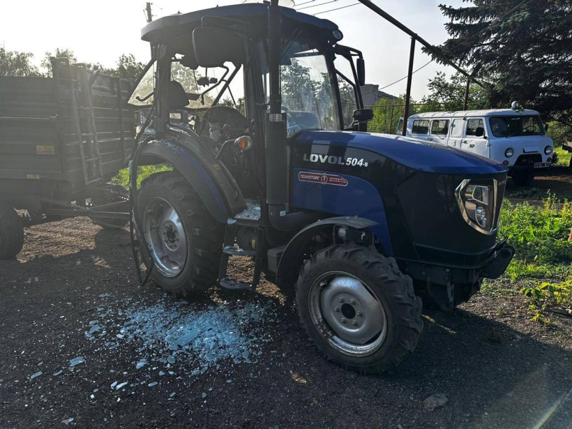 Трактор з причепом, в якого вилетіло скло через ворожий обстріл.