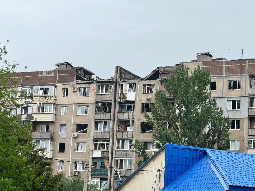 Багатоповерхова будівля з пошкодженою покрівлею, яку зруйнував ворог.